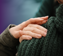 Photo of a person comforting another by placing their hand on their shoulder.