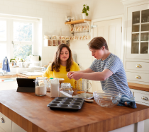 A man and woman cooking in the kitchen.