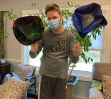 Artist showing off his two sculptures of flowers