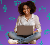 Woman holding a laptop on lap and smiling.