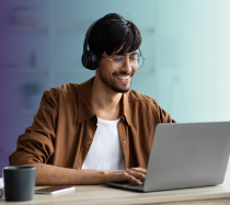 Man with long brown hair attending a webinar on laptop.