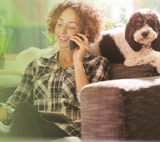 Woman on the phone with EAP provider sitting next to dog. 