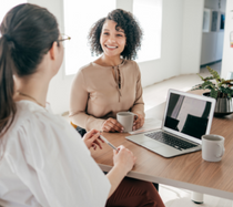 Women discussing benefits over coffee.